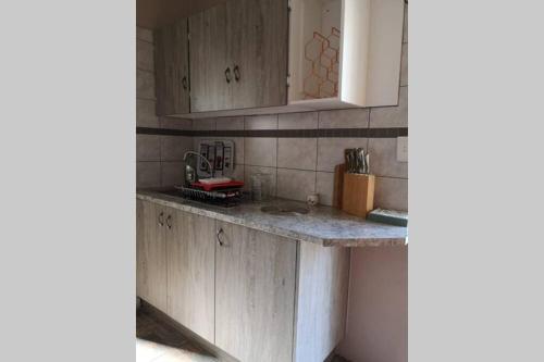 a kitchen with wooden cabinets and a counter top at Ducks Nest in Malelane