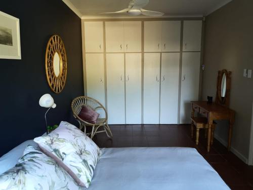 a bedroom with a bed and a chair and a desk at Ducks Nest in Malelane