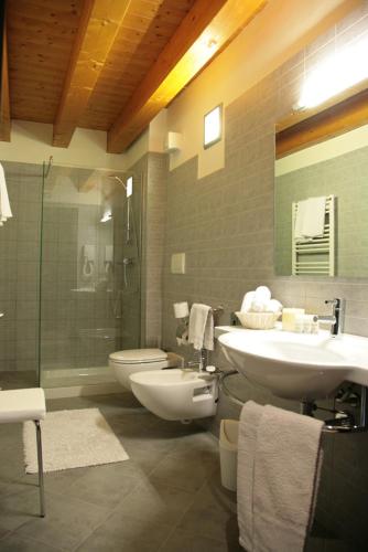 a bathroom with two sinks and a toilet and a shower at Corte Della Rocca Bassa in Nogarole Rocca