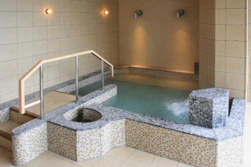 a jacuzzi tub with a pool of water at Shin Furano Prince Hotel in Furano