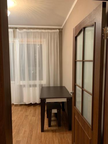 Habitación con mesa de ping pong frente a una ventana en Бориса Гмыри 12Б, en Kiev