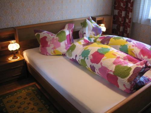 ein Bett mit bunten Kissen darauf im Schlafzimmer in der Unterkunft Haus Antlinger in Reutte