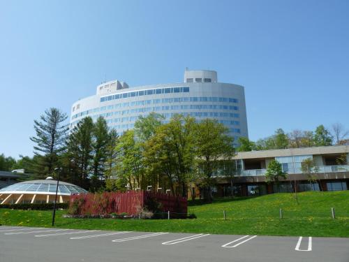 a parking lot in front of a large building at Shin Furano Prince Hotel in Furano