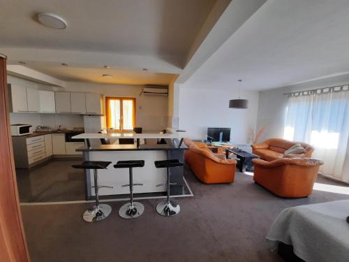 eine Küche und ein Wohnzimmer mit orangefarbenen Stühlen und einer Theke in der Unterkunft Miido Apartments in Kladovo