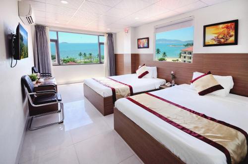 a hotel room with two beds and a view of the ocean at Arise Seaside Hotel in Nha Trang
