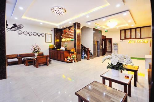 a lobby of a hotel with tables and flowers at Arise Seaside Hotel in Nha Trang