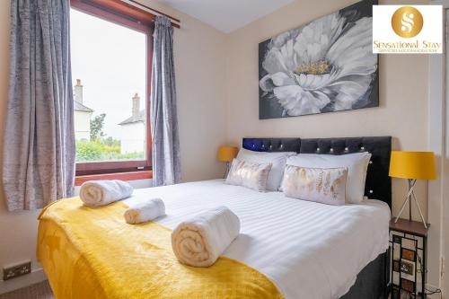 - une chambre avec un grand lit et des serviettes dans l'établissement Sensational Stay Short Lets & Serviced Accommodation 2 bedroom Apartment Aberdeen, Middlefield Place, à Aberdeen