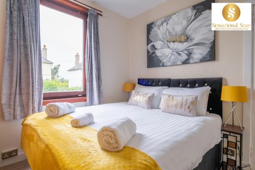 Un dormitorio con una cama grande con toallas. en Sensational Stay Short Lets & Serviced Accommodation 2 bedroom Apartment Aberdeen, Middlefield Place, en Aberdeen
