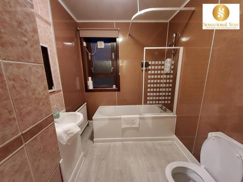 La salle de bains est pourvue d'une baignoire, de toilettes et d'un lavabo. dans l'établissement Sensational Stay Short Lets & Serviced Accommodation 2 bedroom Apartment Aberdeen, Middlefield Place, à Aberdeen