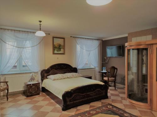 NarewkaにあるDwór Bartnikaのベッドルーム1室(ベッド1台、テーブル、椅子付)