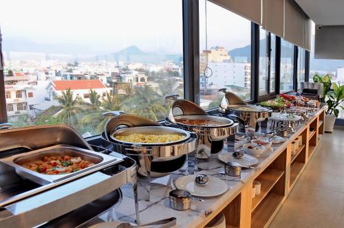 a buffet line with dishes of food on display at Arise Seaside Hotel in Nha Trang