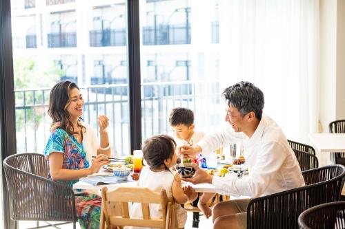 a family eating at a table in a restaurant at Hotel Torifito Miyakojima Resort in Miyako Island