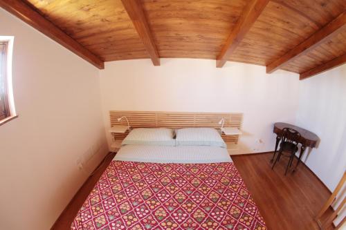 um quarto com uma cama num quarto com tectos em madeira em La Casa del mandarino di Borgo Carbone em Locri