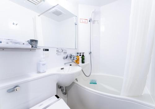a white bathroom with a sink and a shower at APA Hotel & Resort Ryogoku Eki Tower in Tokyo