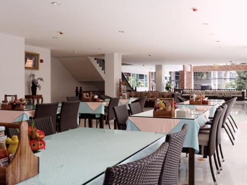 a dining room with tables and chairs in a restaurant at Pattaya Blue Sky in Pattaya Central