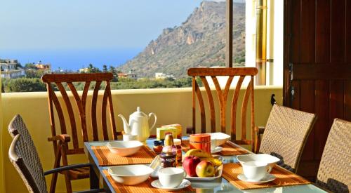 a table with food on it with a view of a mountain at Villa Ravdoucha Homeleader in Ravdhoúkha