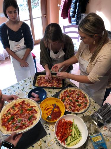 a group of people standing around a table with pizzas at Dolce Vita in Tuscany B&B in Capannori