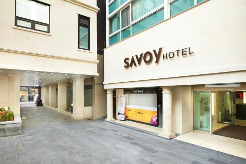 a large building with a savoy hotel sign on it at Savoy Hotel Myeongdong in Seoul