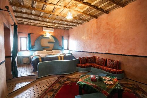 um quarto com uma cama e um sofá num quarto em Ksar Bicha em Merzouga