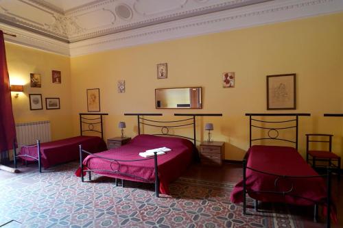 a bedroom with two beds and a mirror on the wall at Hotel Etnea in Catania