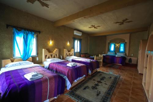 a bedroom with two beds and a mirror at Ksar Bicha in Merzouga