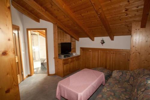 a bedroom with a bed and a flat screen tv at Kleinreiterhof in Bad Reichenhall