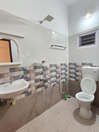 a bathroom with a shower and a toilet and a sink at Calvin's Inn in Cochin