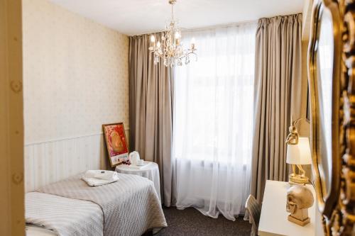 a hotel room with two beds and a window at Old Town Hotel Bohema, Klaipėda in Klaipėda