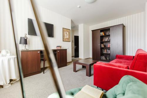 a living room with a red couch and a table at Old Town Hotel Bohema, Klaipėda in Klaipėda