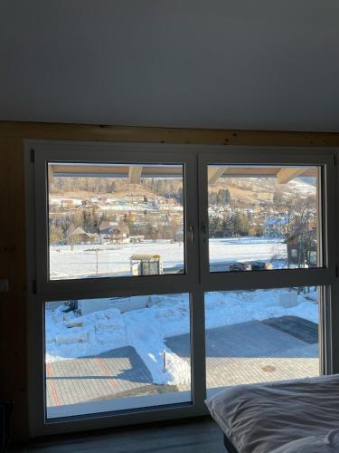 a bedroom window with a view of a snow covered yard at Villa Kreischberg in Sankt Lorenzen ob Murau