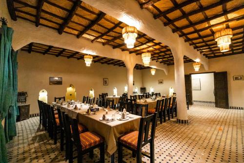 a dining room with tables and chairs in a building at Ksar Bicha in Merzouga