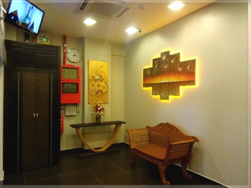 una sala de espera con una silla y un reloj en la pared en GoodHope Hotel, Kelana Mall, en Petaling Jaya