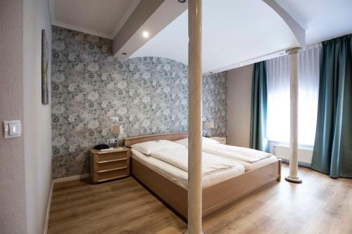 ein Schlafzimmer mit einem Himmelbett in einem Zimmer in der Unterkunft Hotel Landhaus zur Issel in Isselburg