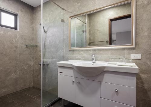 a bathroom with a sink and a glass shower at 名竹旅社 Minzu Hotel in Lugu