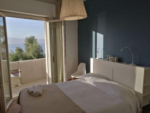 een slaapkamer met een bed en een groot raam bij Vista sullo stretto in Reggio di Calabria