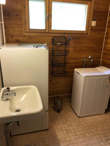 a bathroom with a sink and a refrigerator at Lupiini in Savonlinna