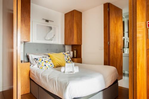 - une petite chambre avec un lit et des oreillers jaunes dans l'établissement Kate Home's Trindade Apartments - Porto's City Centre, à Porto