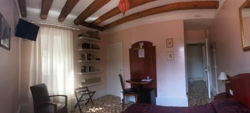 sala de estar con sofá, mesa y ventana en B&B a le Boteghe en Venecia
