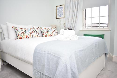- une chambre avec un lit blanc et une fenêtre dans l'établissement Bernard St - Bright and spacious 1 bed apartment at the Shore!, à Édimbourg