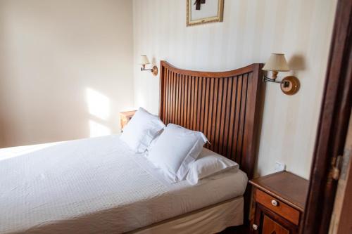 a bedroom with a bed with white sheets and pillows at La Casona de Hermosa in Hermosa