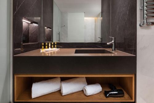 a bathroom with a sink and a counter with towels at Eurostars Aliados in Porto