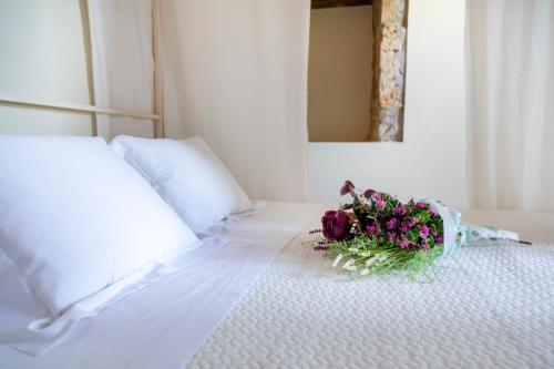 a white bed with a bouquet of flowers on it at La Casona de Hermosa in Hermosa