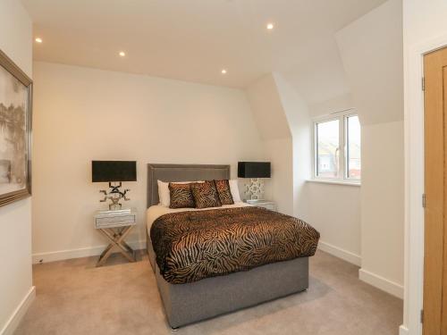 Un dormitorio con una cama y dos lámparas y una ventana. en Harbourside Haven Penthouse 2, en Weymouth