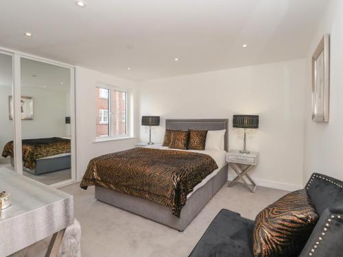 a bedroom with a large bed and a couch at Harbourside Haven Apartment 1 in Weymouth
