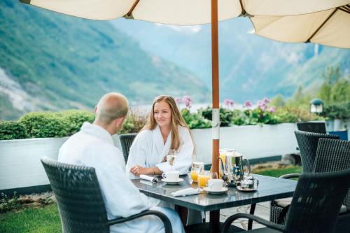 a man and a woman sitting at a table in a restaurant at Hotel Union Geiranger Bad & Spa in Geiranger