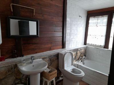 a bathroom with a sink and a toilet and a tub at El Molino de Candelario in Candelario