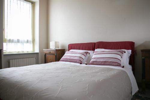 a bedroom with a bed with red and white pillows at IseoLakeRental - Villa Dossello in Solto Collina