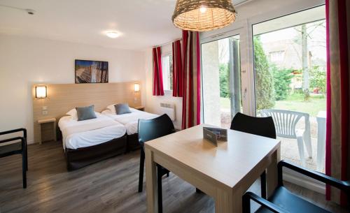 a hotel room with a bed and a table and chairs at Hippotel in Le Touquet-Paris-Plage