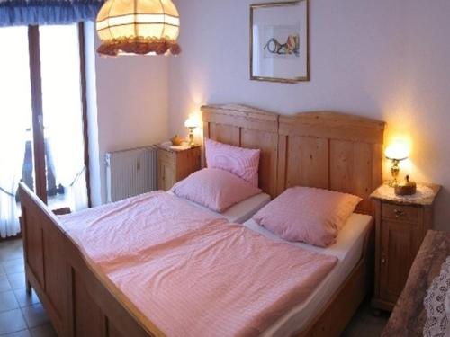 ein Schlafzimmer mit einem großen Bett mit zwei rosa Kissen in der Unterkunft Haus Wendelweg in Unterwössen