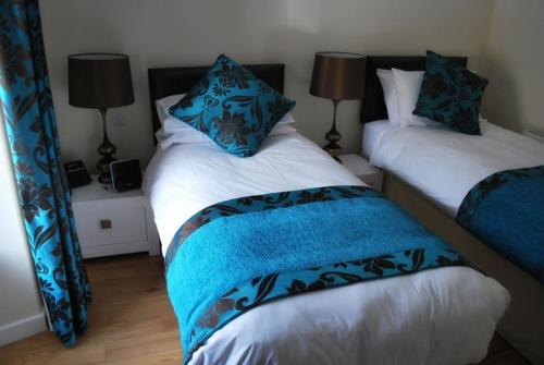a bedroom with two beds with blue and white sheets at The Aberlour Hotel in Aberlour